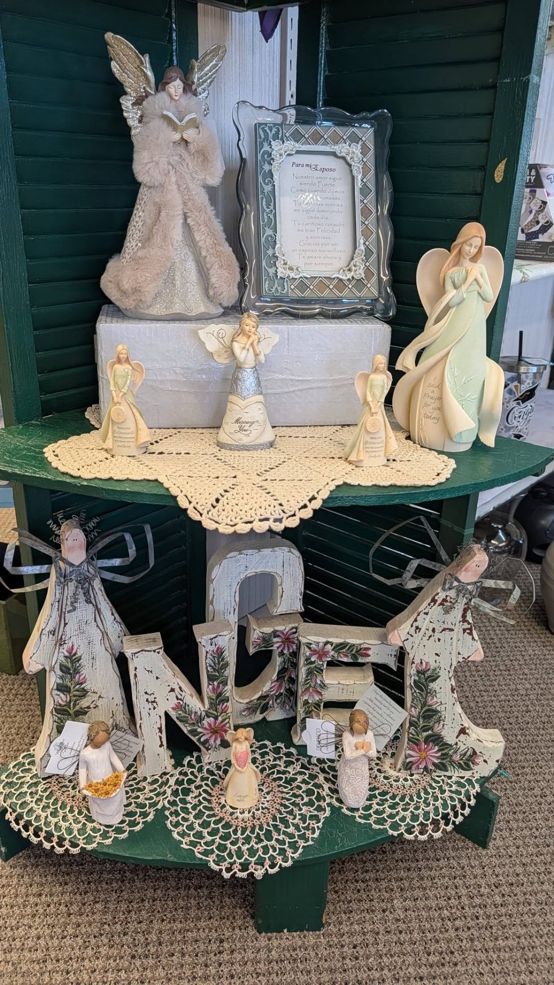 Display of angel figurines with NOEL decor and lace doilies.