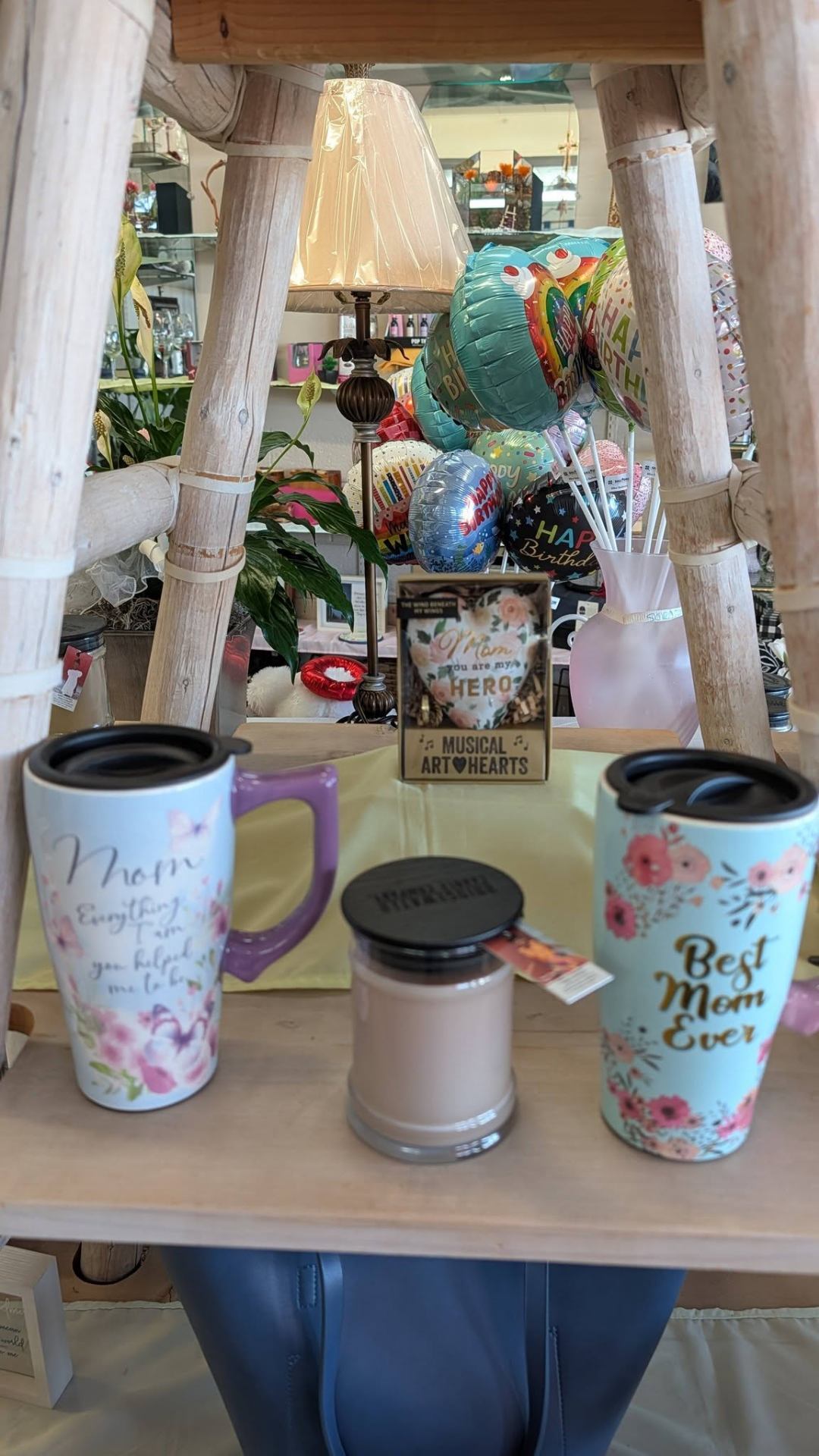 Mom mugs, candles, and birthday balloons arranged in the gift shop.
