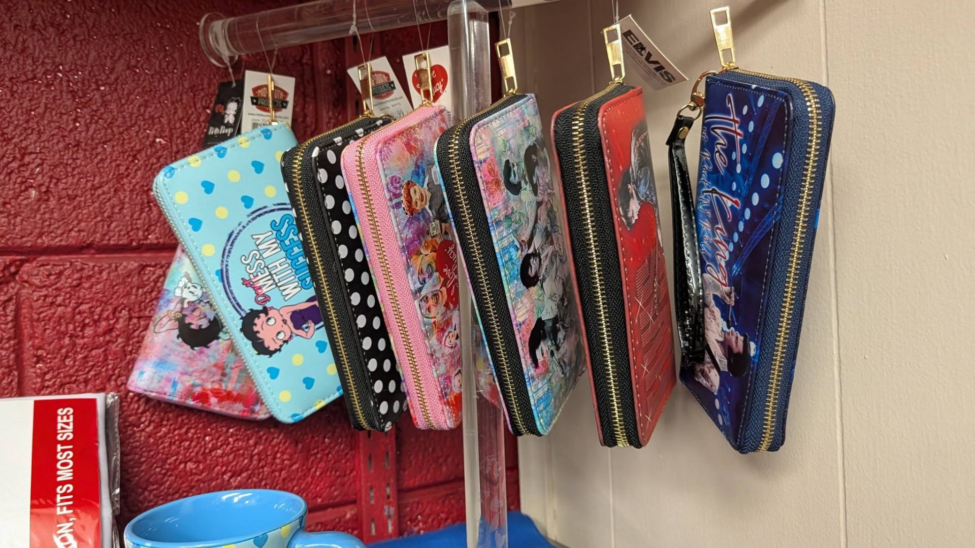 Hanging novelty wallets featuring Betty Boop, Elvis, and Lucy designs.