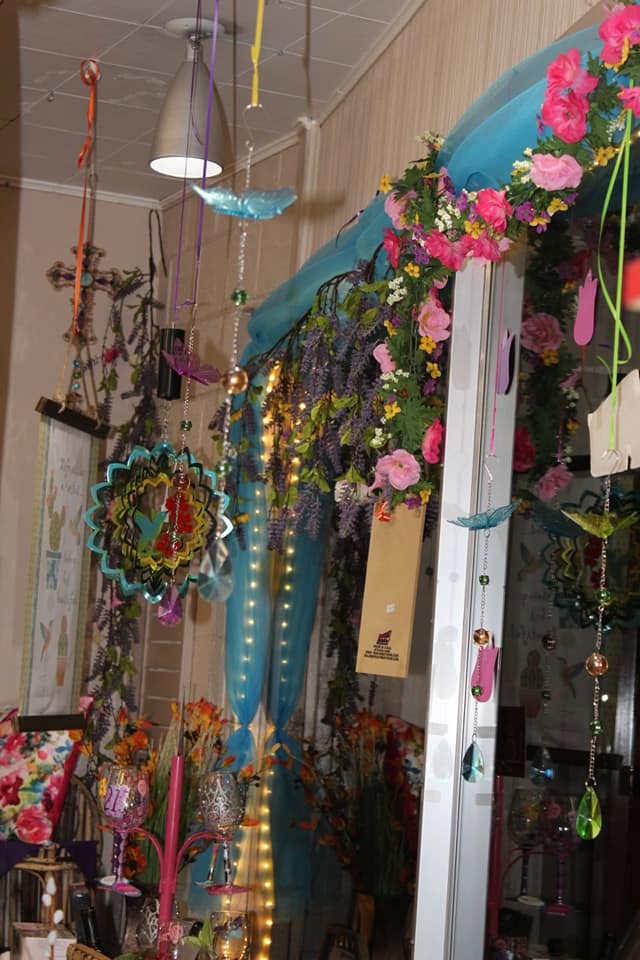 Whimsical floral window display with hanging crystals and lights inside Fascinating Things Flowers & Gifts in Parker, Arizona.